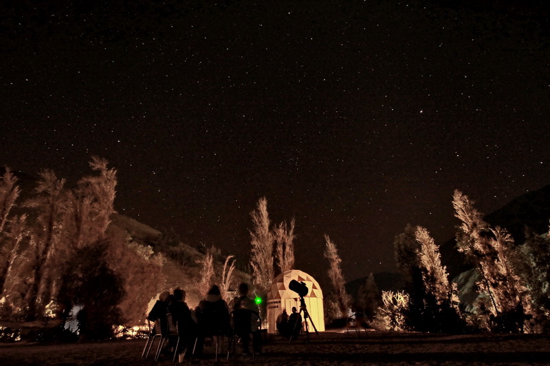 Telescopio bajo el cielo estrellado en Observatorio Chakana